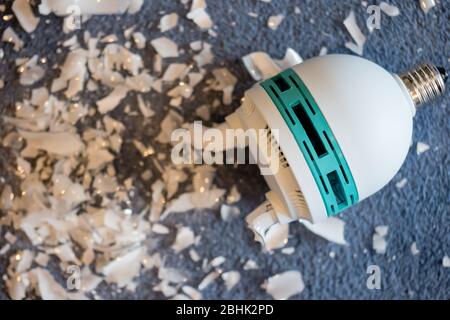 Une lampe studio de photographe cassée - lampe fluorescente compacte ou lampe CFL - qui a libéré la vapeur de mercure Banque D'Images