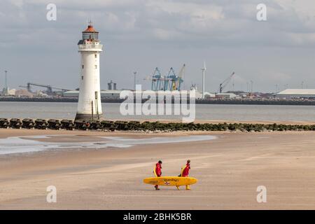 Des sauveteurs transportant des planches de surf sur la plage, New Brighton, Merseyside Banque D'Images