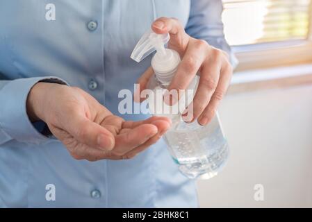 Femme nettoyant ses mains avec du gel aseptisant à base d'alcool pour éviter la propagation du coronavirus. Hygiène et concept Covid-19. Banque D'Images