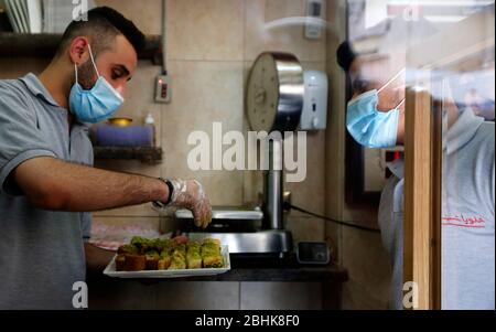 Beyrouth, Liban. 26 avril 2020. Un homme achète des bonbons pendant le Ramadan, en raison de la pandémie de COVID-19 à Beyrouth, au Liban, le 26 avril 2020. Le nombre d'infections au COVID-19 au Liban a augmenté dimanche de trois cas pour atteindre 707 alors que le nombre de décès est resté inchangé à 24, a indiqué l'Agence nationale de presse. Crédit: Bilal Jawich/Xinhua/Alay Live News Banque D'Images