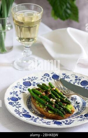 Sandwich au pain de grains entiers végétaliens avec asperges, purée de pois, noix et sauce soja. Banque D'Images