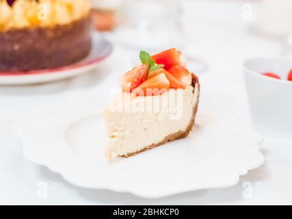 Gâteau au fromage aux fraises fraîches sur une plaque en céramique sur un tableau blanc Banque D'Images