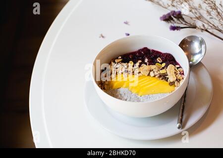 Bol à smoothie aux baies de petit-déjeuner avec myrtilles, amandes, bananes et graines de chia. Banque D'Images