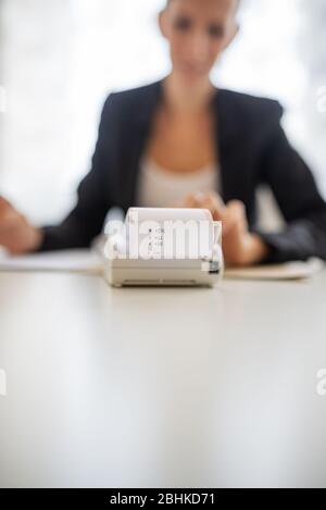 Jeune comptable travaillant sur le rapport annuel ou la fiscalité à l'aide d'une machine d'ajout. Avec l'accent sur le reçu financier. Banque D'Images