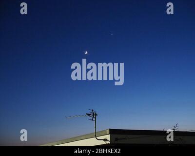 Sheerness, Kent, Royaume-Uni. 26 avril 2020. Météo britannique: La lune de croissant près de Vénus dans le ciel du soir au-dessus de la Sheerness. Crédit: James Bell/Alay Live News Banque D'Images