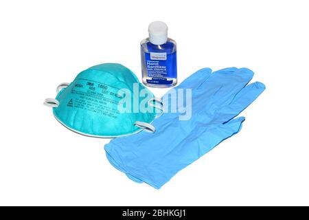 Un flacon de désinfectant pour les mains, un masque respiratoire N95 chirurgical et des gants jetables en nitrile isolés sur un fond blanc. Image découpée. Banque D'Images