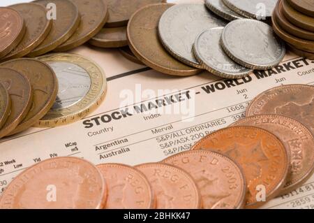 Pièces diverses sur la photo en haut d'une page de journal des marchés boursiers. Banque D'Images