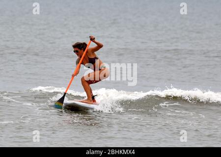 Kennedy Space Center, États-Unis. 26 avril 2020. Une jeune femme du centre de la Floride surfe le dimanche 26 avril 2020, le long des plages près de la gare de Patrick Air Force. L'État de Floride a commencé à ouvrir ses plages au grand public, car la menace du virus Covid-19 commence à se faire subside. Photo de Joe Marino/UPI crédit: UPI/Alay Live News Banque D'Images