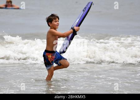 Kennedy Space Center, États-Unis. 26 avril 2020. Un jeune garçon du centre de la Floride fait du surf près de Cocoa Beach, en Floride, dimanche 26 avril 2020. L'État de Floride a commencé à ouvrir des plages au grand public, car la menace du virus Covid-19 commence à se faire subside. Photo de Joe Marino/UPI crédit: UPI/Alay Live News Banque D'Images