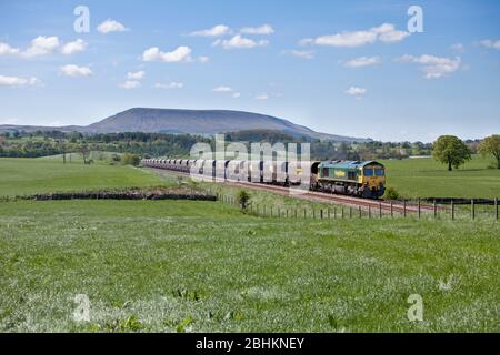 La locomotive Freightliner classe 66 66520 transporte un train de marchandises à charbon « Merry Go round » sur la Blackburn jusqu'à Hellifield Railway, Pendle Hill est derrière. Banque D'Images