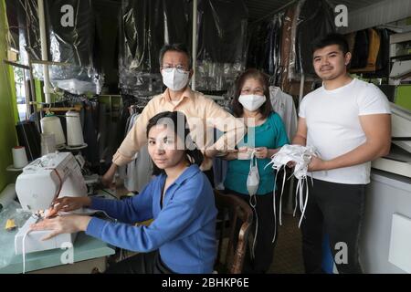 UNE FAMILLE VIETNAMIENNE FAIT DES MASQUES FACIAUX PENDANT LE MAINTIEN PARISIEN DANS SON SÈCHE-LINGE FERMÉ Banque D'Images