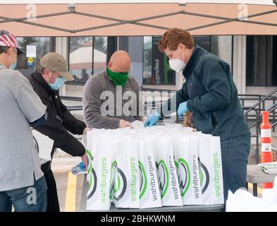 24 avril 2020, Norwood, Massachusetts, États-Unis: Le représentant américain Joe Kennedy III (D-ma) se joignant aux hamburgers pour distribuer des repas aux membres de Teamsters local 25 qui conduisent pour UPS, en dehors d'UPS Norwood. Whalburgers est la propriété du Chef Paul Wahlberg, frère de Donnie et de Mark Wahlberg. Banque D'Images