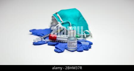 Flacon de vaccin d'essai Covid-19 sur gants médicaux, tube vide et masque respiratoire de type N-95. Banque D'Images