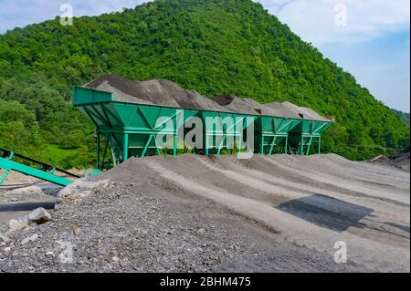 Usine de mélange chaud d'asphalte. Système d'alimentation d'agrégats froids de l'usine d'asphalte. Conteneur avec sable et granulat - poussière de pierre dans les proportions correctes Banque D'Images