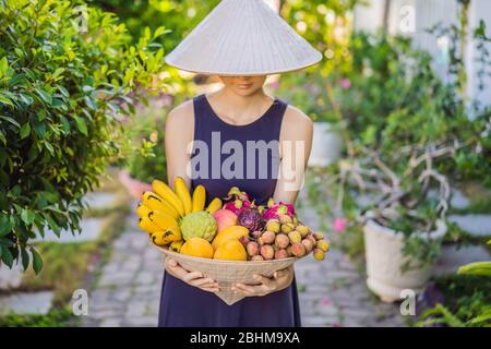 Variété de fruits dans un chapeau vietnamien. Femme dans un chapeau vietnamien Banque D'Images