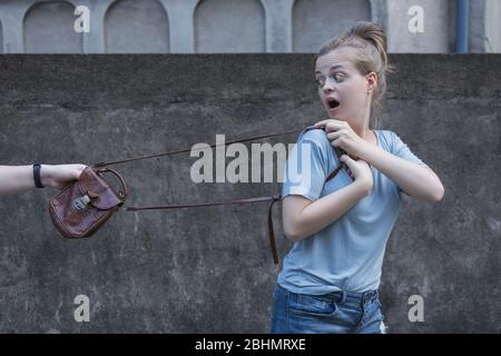 Une jeune femme blanche effrayée est volée de son sac. Concept d'attaque de vol de rue Banque D'Images