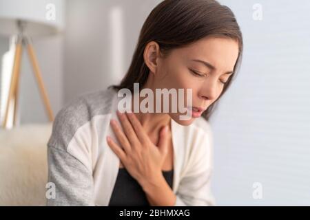 COVID-19 difficultés respiratoires femme avec essoufflement problème de respiration de la toux de Coronavirus. Fille asiatique dans la douleur touchant les symptômes respiratoires de la poitrine fièvre, toux, douleurs du corps. Banque D'Images