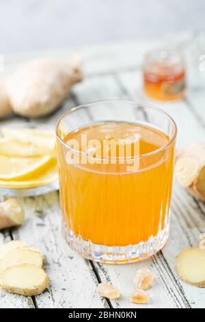 Boisson jaune au gingembre, au citron et à la glace dans un verre, limonade au gingembre maison rafraîchissante ou ALE sur fond blanc Banque D'Images