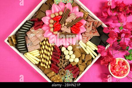 Assiette de pacage en charcuterie au dessert au chocolat avec un large choix de chocolat noir, au lait, blanc et rubis sur fond rose moderne pour la fête des mères ou Banque D'Images