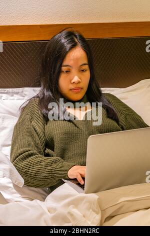 Femme rester à la maison et travailler sur ordinateur portable Banque D'Images