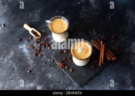 Deux tasses en verre avec café à la crème Dalgona tendance à boire un espresso au latte coréen avec mousse de café sur fond noir. Banque D'Images