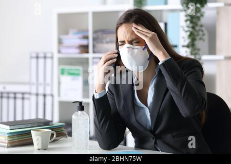 Femme de haut niveau avec maux de tête sur smartphone portant un masque de protection Banque D'Images