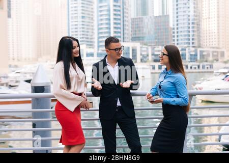 Homme d'affaires et deux femmes discutant d'une réunion dans la ville. Trois personnes en voyage d'affaires parlent au centre d'affaires Way Park et en plein air. Banque D'Images