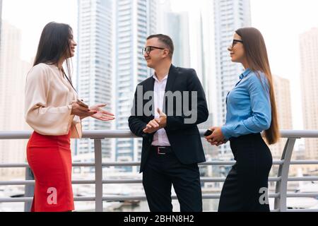 Homme d'affaires et deux femmes discutant d'une réunion dans la ville. Trois personnes en voyage d'affaires parlent au centre d'affaires Way Park et en plein air. Banque D'Images