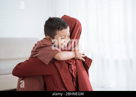 Petit garçon embrassant sa mère de s'excuser lors de la célébration heureux Eid UL-Fitr Banque D'Images