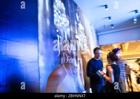 Hong Kong - juin,9 2013: Exposition multiple d'une femme dans le centre commercial de Hong Kong devant la Dior publicité Banque D'Images