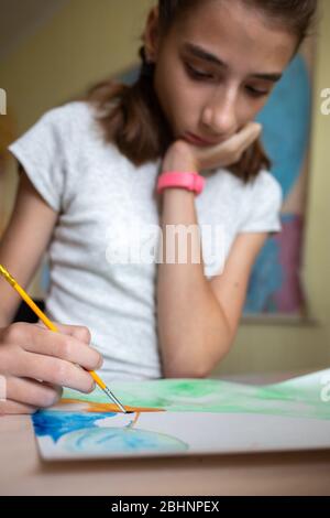 Jeune fille dessin avec aquarelles à la maison pendant la quarantaine Banque D'Images