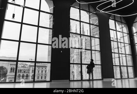 Museo del Novecento, Milan, Italie. Photographie noir et blanc de l'intérieur du musée. Une personne seule est en affamée sur la Piazza del Duomo Banque D'Images