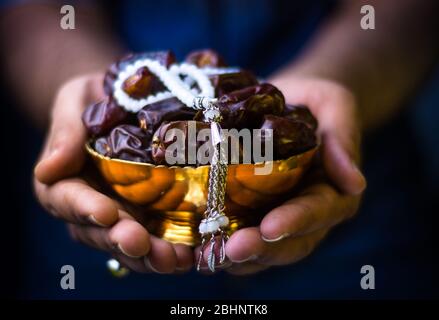 Mains avec dates et tasbeeh ramadan kareem concept, le jeûne et les fruits iftar fond Banque D'Images