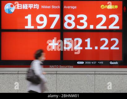 Tokyo, Japon. 27 avril 2020. Un passage piéton passe avant la planche à Tokyo le lundi 27 avril 2020. Les cours des actions japonaises ont augmenté de 521,22 yens pour se fermer à 19 783,22 yens à la Bourse de Tokyo. Crédit: Yoshio Tsunoda/AFLO/Alay Live News Banque D'Images