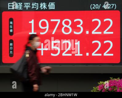 Tokyo, Japon. 27 avril 2020. Un passage piéton passe avant la planche à Tokyo le lundi 27 avril 2020. Les cours des actions japonaises ont augmenté de 521,22 yens pour se fermer à 19 783,22 yens à la Bourse de Tokyo. Crédit: Yoshio Tsunoda/AFLO/Alay Live News Banque D'Images