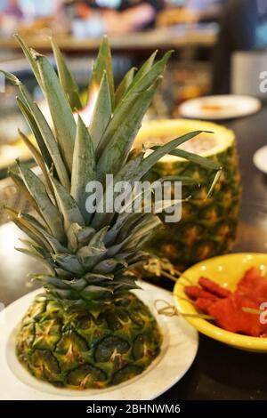 Cocktail Pina Colada dans une tasse de ananas servi avec des morceaux d'ananas au feu Banque D'Images