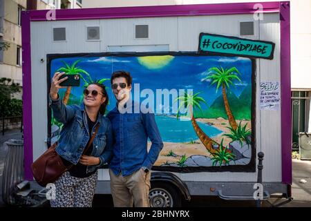 Paris. 26 avril 2020. Les gens prennent selfie devant une fresque installée par le peintre français et l'artiste graffiti Katre dans une rue à Paris, France, le 26 avril 2020, pendant le maintien pour arrêter la propagation de COVID-19. Crédit: Aurelien Morissard/Xinhua/Alay Live News Banque D'Images