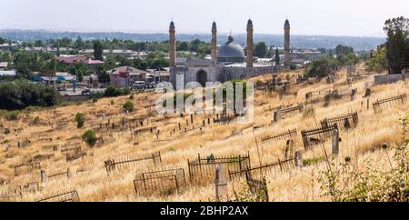 Osh, Kirghizistan - JUne29, 2019: Le cimetière avec tombes et mosquée sur le versant d'une colline dans le village d'Osh, Kirghizstan. Banque D'Images