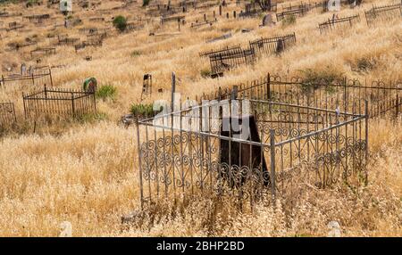 Osh, Kirghizstan - JUne29, 2019: Le cimetière avec des tombes sur la pente d'une colline dans le village d'Osh, Kirghizstan. Banque D'Images