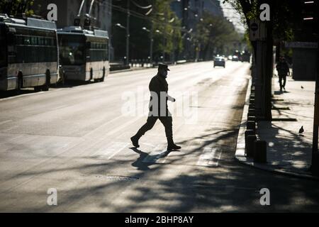 Bucarest, Roumanie - 22 avril 2020 : silhouette d'un soldat traversant une route dans le centre de Bucarest pendant le verrouillage du covid-19 au crépuscule. Banque D'Images