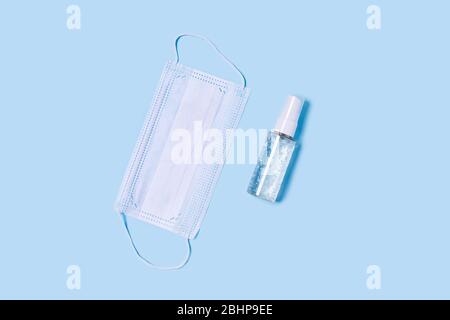 Disposez à plat avec un masque médical placé au centre, une bouteille de savon antiseptique ou de désinfectant pour les mains. Banque D'Images