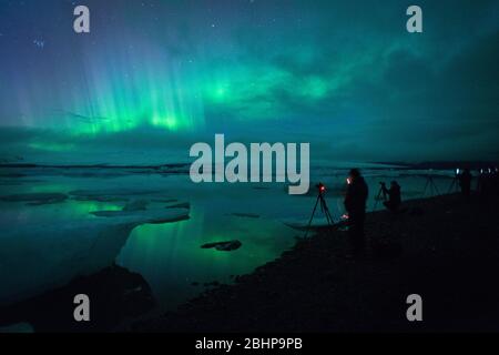 Photographes photographiant l'Aurora Borealis au lac glaciaire de Jökulsárlón, Islande Banque D'Images