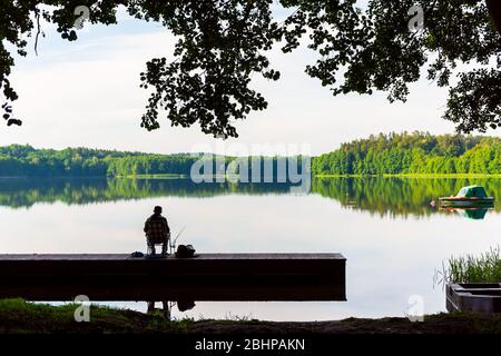 Silhouette de pêcheur. Pêche sur le lac à l'aube. Calme détente nature scène Banque D'Images