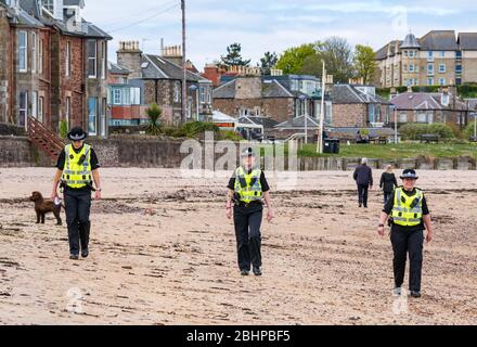 North Berwick, East Lothian, Écosse, Royaume-Uni. 27 avril 2020. Trois policiers de la plage ouest de patrouille d'Édimbourg. Les plages de la ville balnéaire sont presque désertes et ceux qui sont dehors sont tous maintenir des distances sociales appropriées Banque D'Images