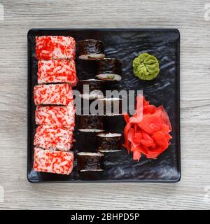 Ensemble de deux types de sushis. Sushi sur un plat carré noir avec gingembre et wasabi. Banque D'Images