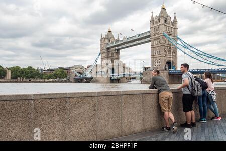 Touristes à Tower Bridge, Londres, Royaume-Uni. Un groupe familial visitant le célèbre monument de Londres, Tower Bridge sur la Tamise. Banque D'Images