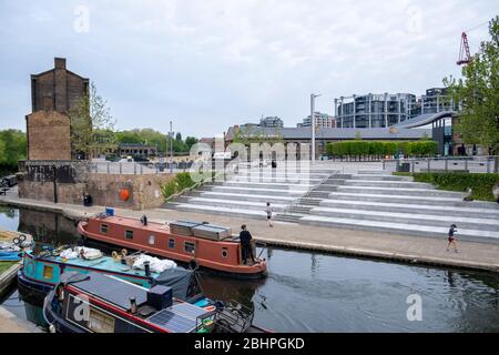 Londres LockDown : une barge sur le canal Regents passe Granary Square, Kings Cross, normalement occupé mais vide en raison du verrouillage de la covid-10 à Londres, au Royaume-Uni Banque D'Images