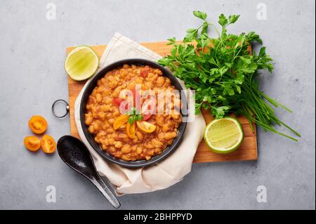 Fava ou MEDAMES Fava en bol noir sur fond gris. Le foul Mudammas est un plat de petit-déjeuner de cuisine égyptienne, libanaise, syrienne, érythréenne et israélienne Banque D'Images