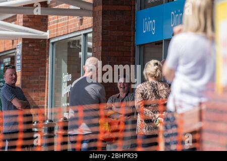 Les clients du Gallagher Retail Park doivent faire face à de longues files d'attente en dehors des M&S et B&M pendant le verrouillage national du coronavirus. Banque D'Images