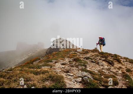 Sac à dos de randonneur avec montée. Randonneur montant vers le sommet de la montagne sur un sentier très raide. Banque D'Images